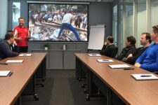 Trainer opening a presentation with a personal story beside a projected photo