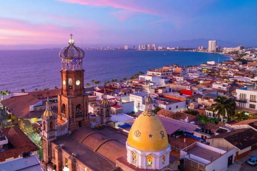 Puerto Vallarta's crowned church tower and bay at sunset, home of ProSpeak's destination workshops